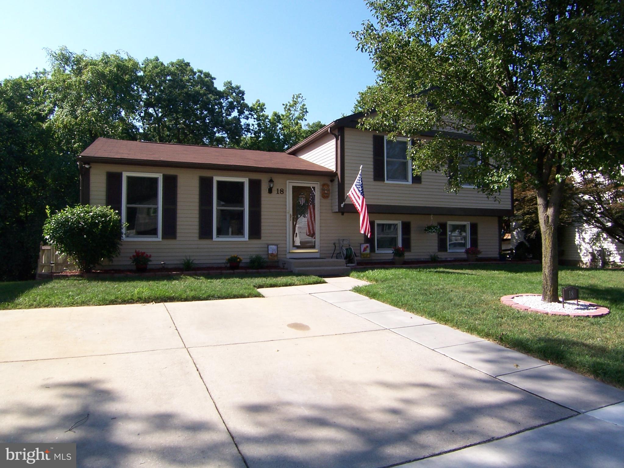 a front view of a house with a garden and trees