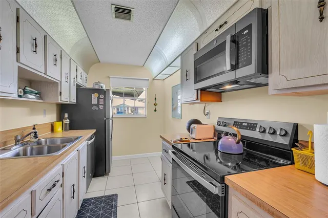 a kitchen with stainless steel appliances granite countertop a stove a sink dishwasher and cabinets with wooden floor