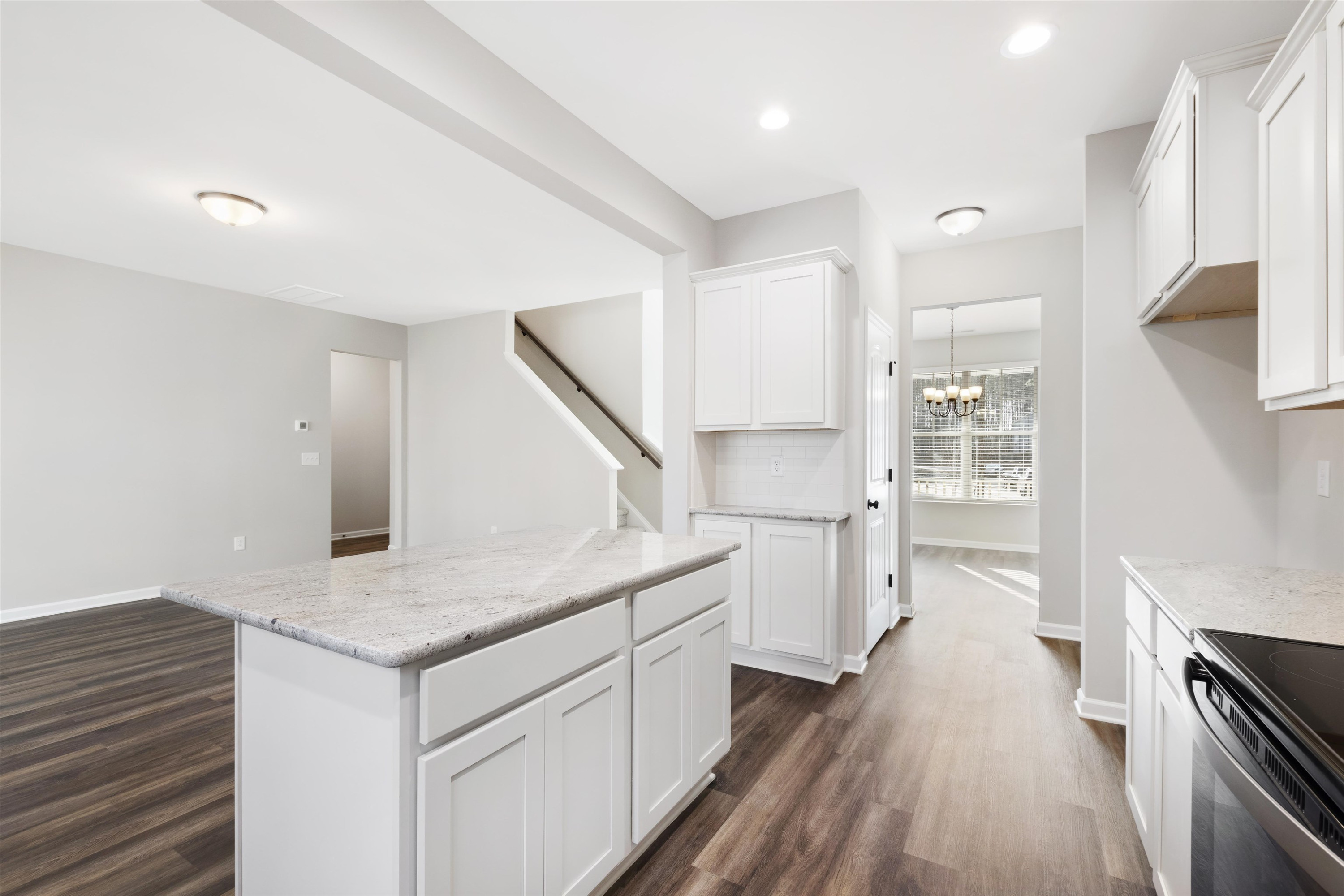 372 Nickleby Way Wendell, NC 27591 - Photo 11 of 37 a kitchen with white cabinets and wooden floor