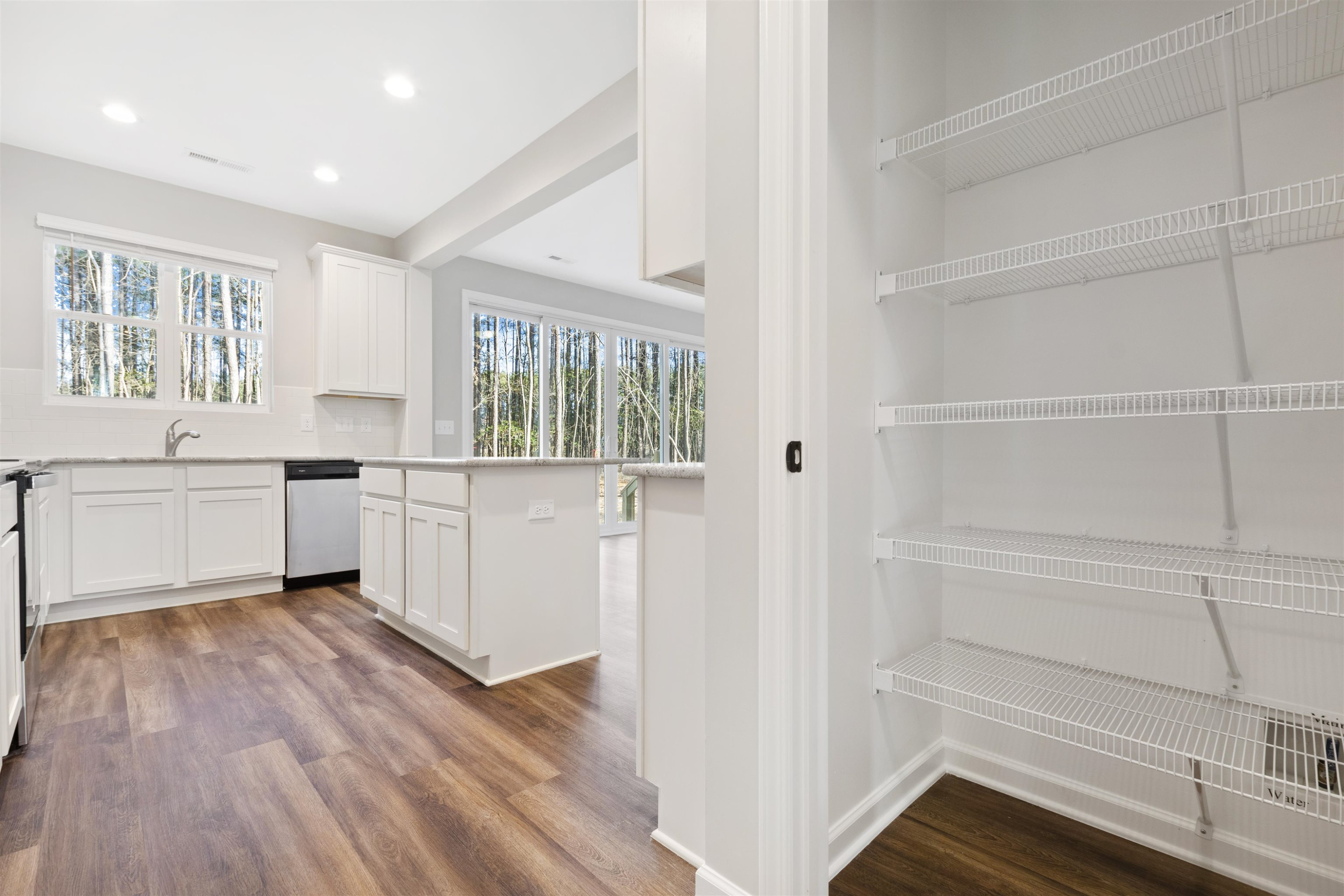 372 Nickleby Way Wendell, NC 27591 - Photo 12 of 37 a kitchen with white cabinets and white appliances