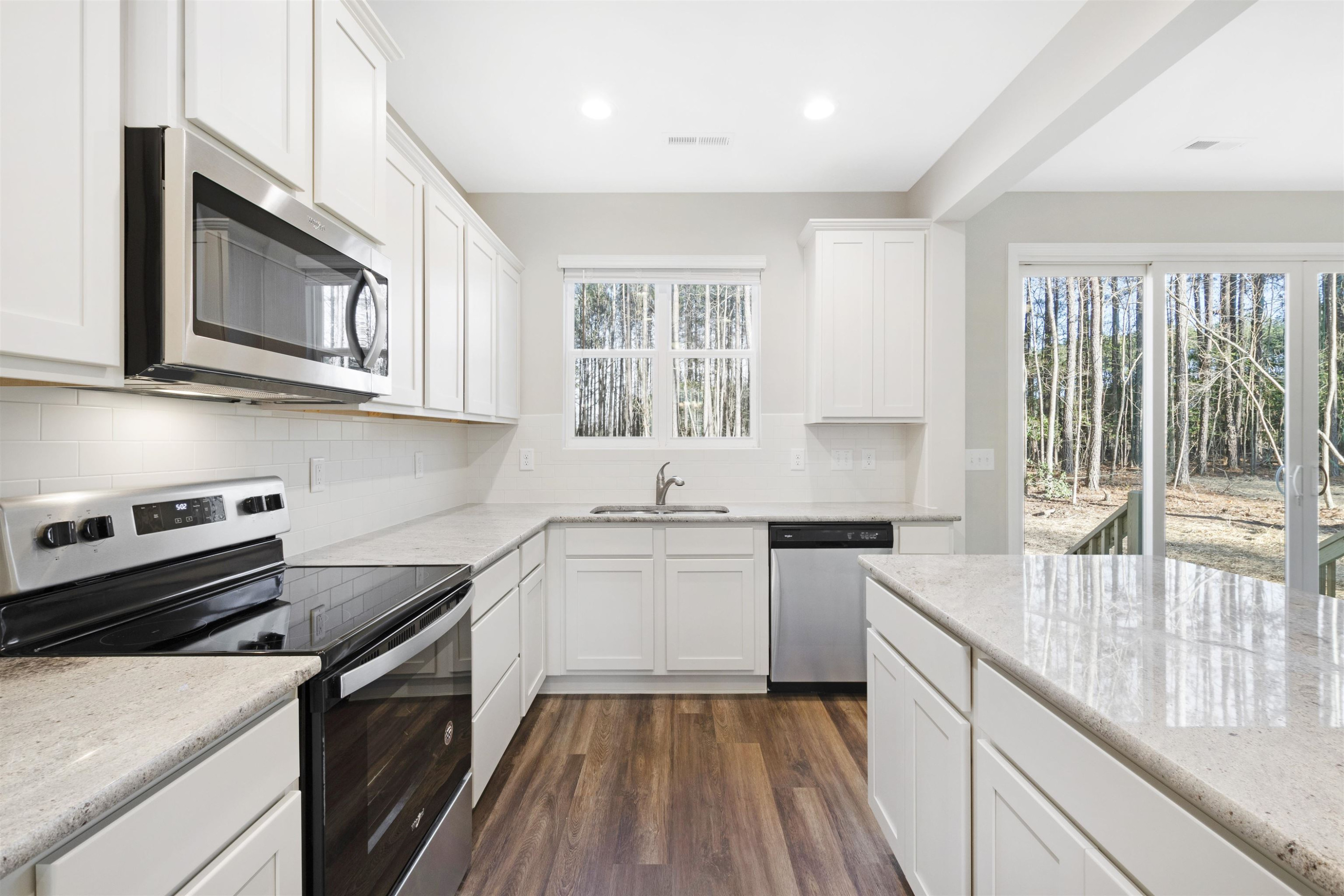372 Nickleby Way Wendell, NC 27591 - Photo 13 of 37 a kitchen with stainless steel appliances granite countertop a stove a sink and a microwave