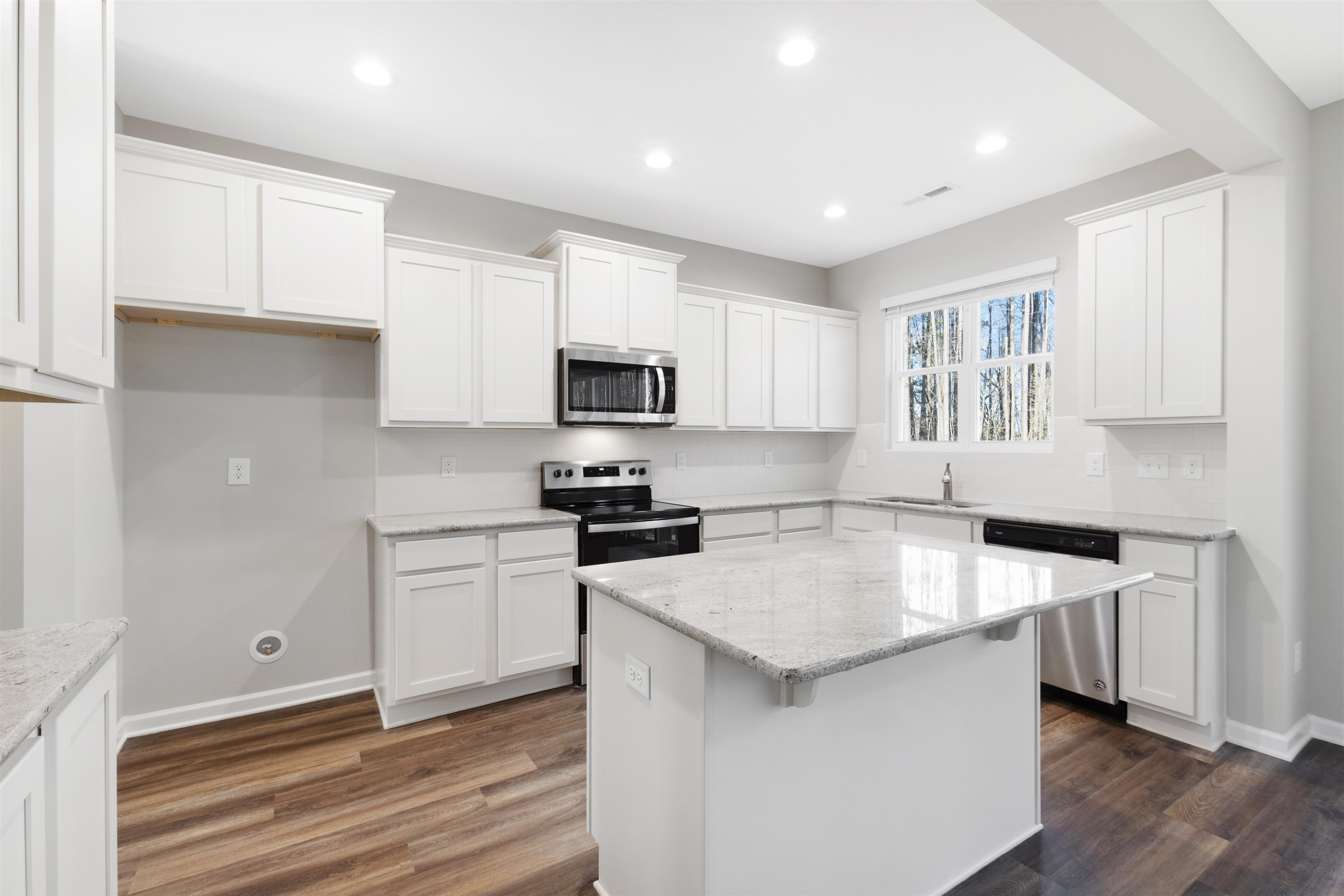 372 Nickleby Way Wendell, NC 27591 - Photo 14 of 37 a kitchen with granite countertop a sink stove and refrigerator