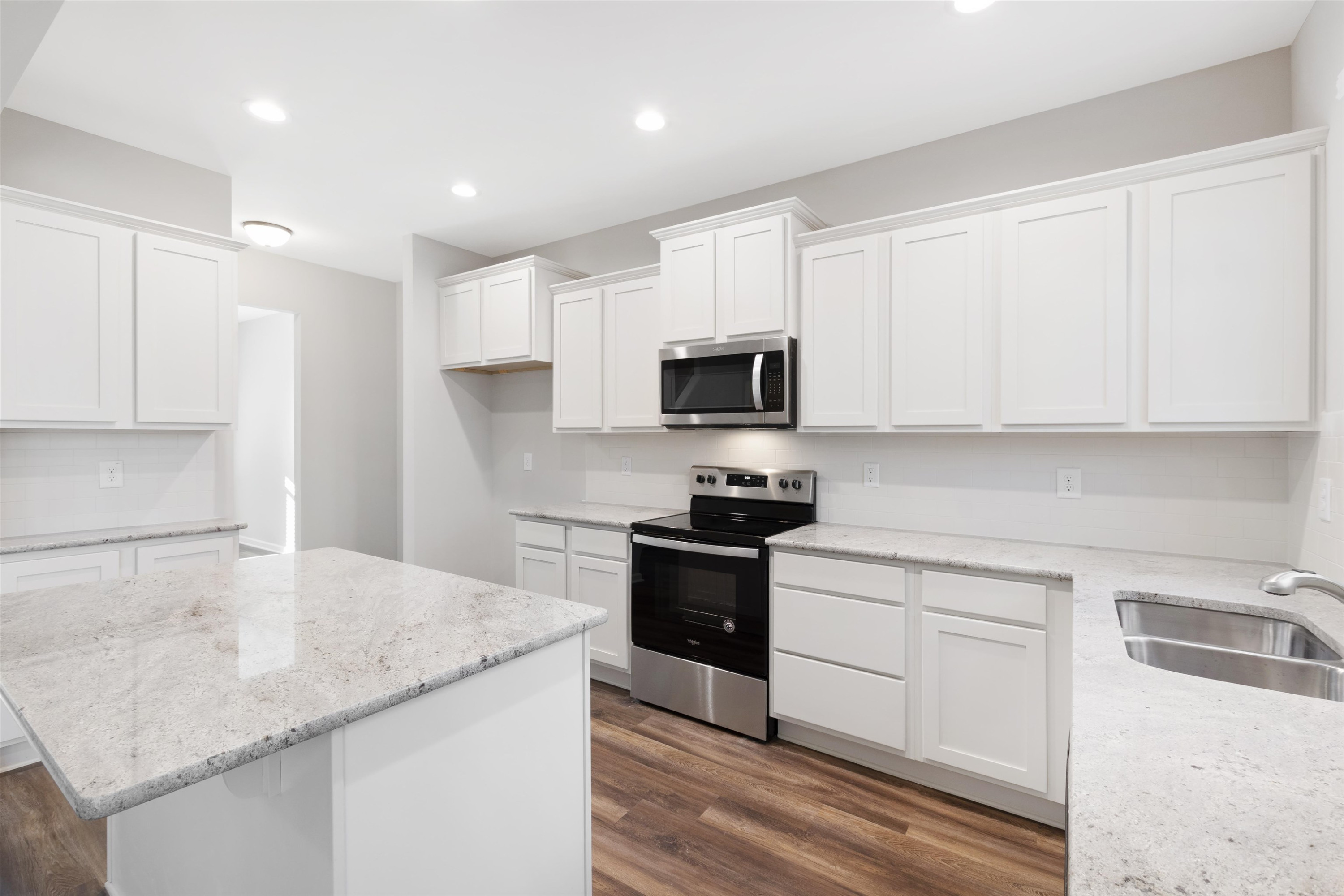 372 Nickleby Way Wendell, NC 27591 - Photo 4 of 37 a kitchen with granite countertop white cabinets and a stove