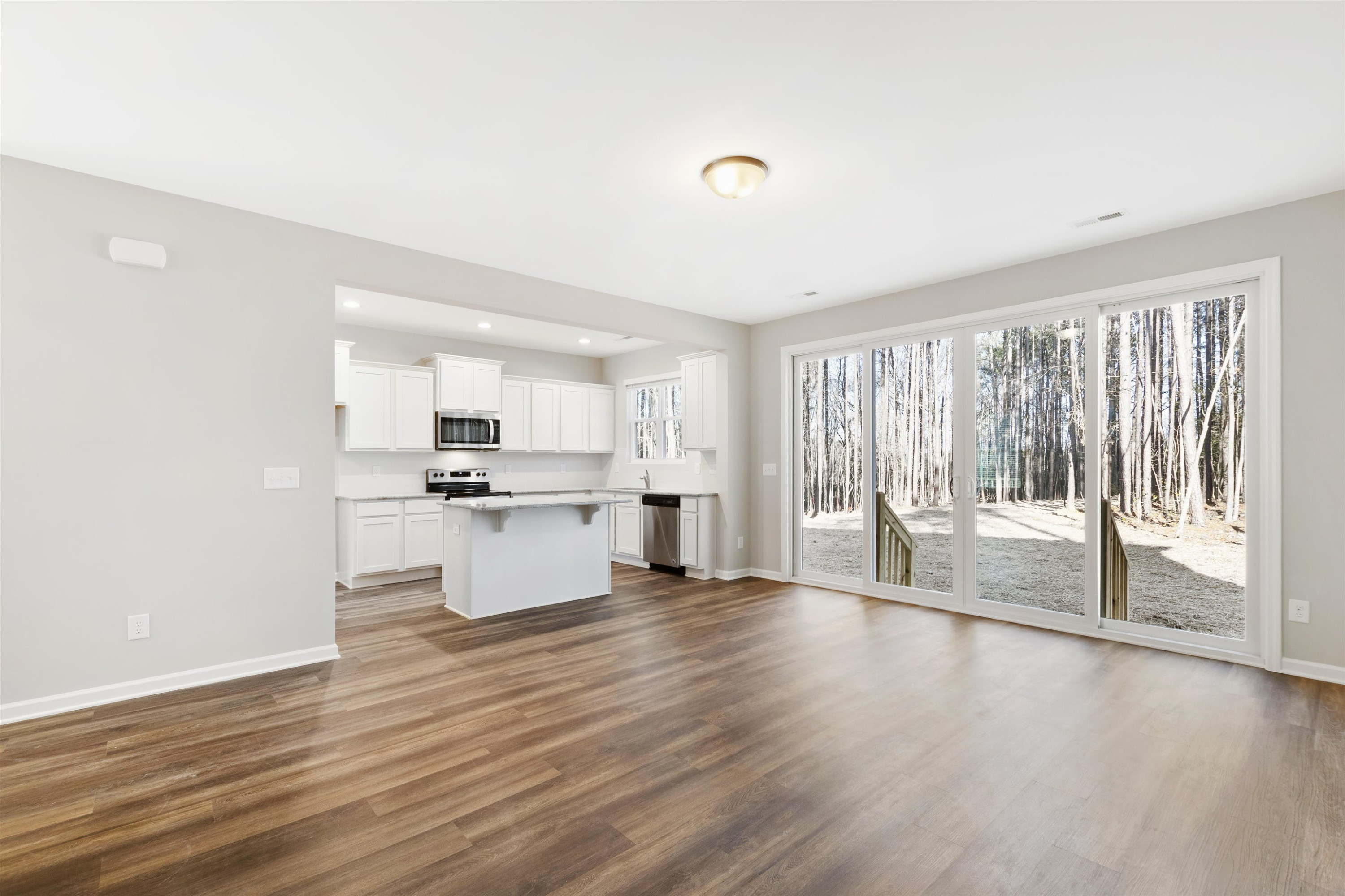 372 Nickleby Way Wendell, NC 27591 - Photo 10 of 37 a large kitchen with white cabinets and wooden floor
