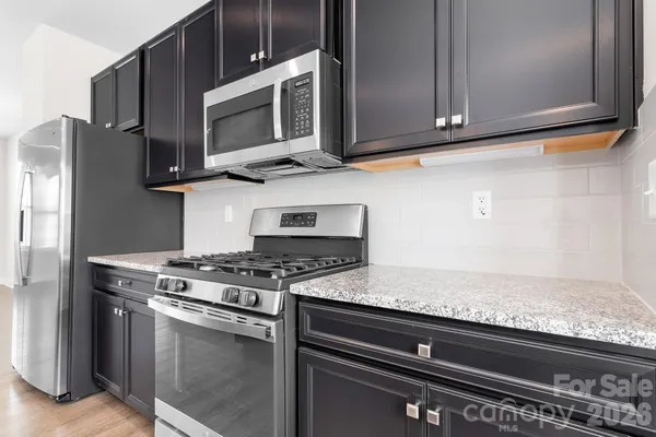 a kitchen with stainless steel appliances granite countertop a stove microwave and oven