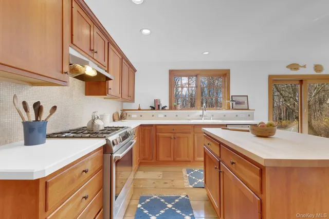 a kitchen with stainless steel appliances granite countertop a sink stove and cabinets