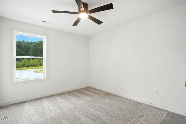 an empty room with a window and a fan