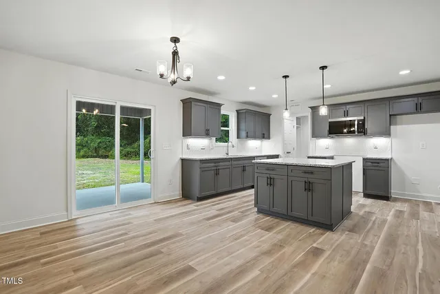 a large kitchen with kitchen island a sink stainless steel appliances and cabinets