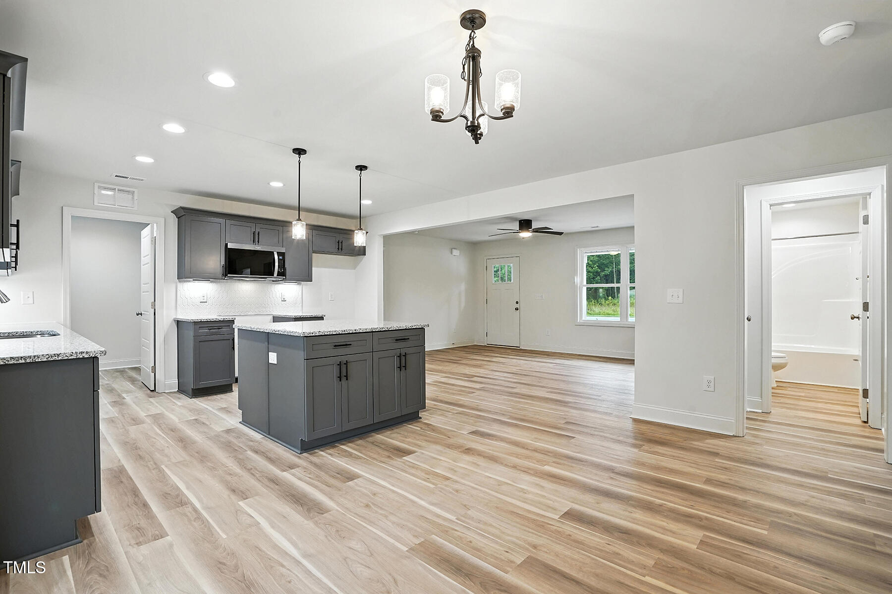 8670 Green Path Road Dunn, NC 28334 - Photo 20 of 34 a large kitchen with a center island wooden floor stainless steel appliances and cabinets