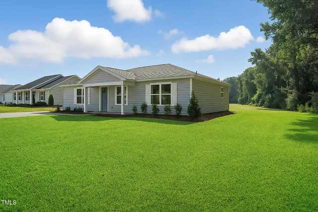a view of a house with a big yard and potted plants