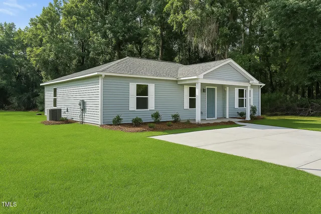 a front view of a house with a garden