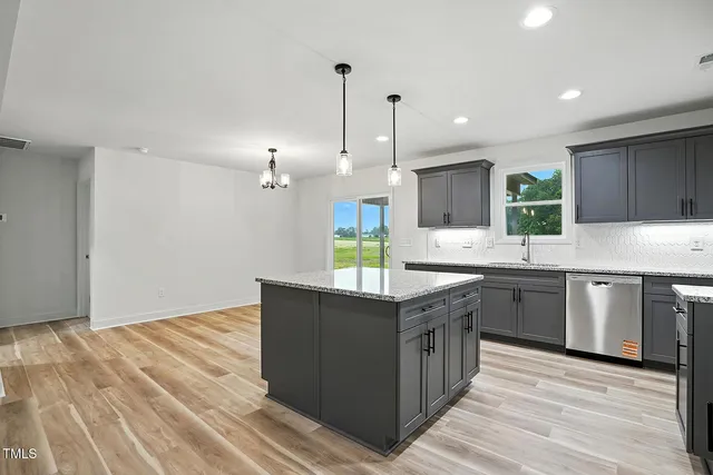 a kitchen with granite countertop a sink and cabinets