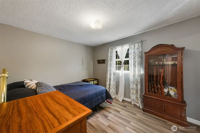 a bedroom with two beds and wooden floor