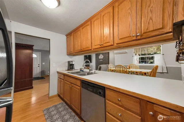 a kitchen with stainless steel appliances granite countertop a sink a stove and a wooden floors