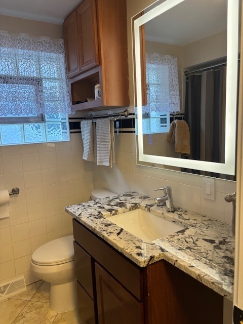 5131 Latrobe Avenue Chicago, IL 60638 - Photo 8 of 23 a bathroom with a granite countertop sink and a toilet