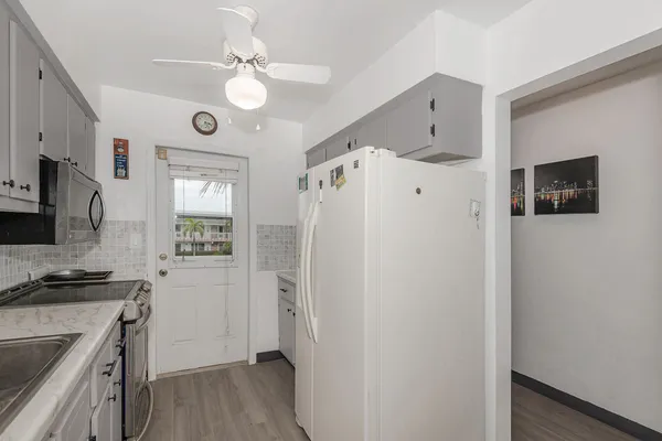 a kitchen with a refrigerator a stove top oven a sink a window and a window