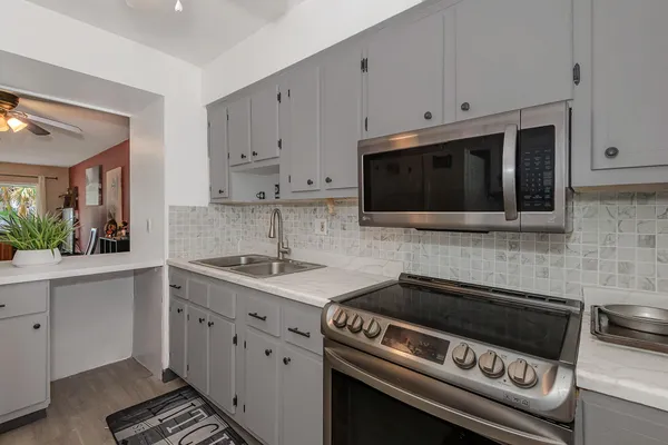a kitchen with stainless steel appliances a stove a sink and a microwave
