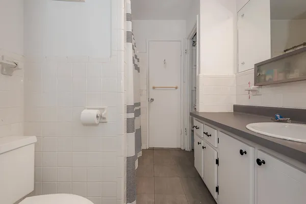 a bathroom with a granite countertop sink mirror and toilet