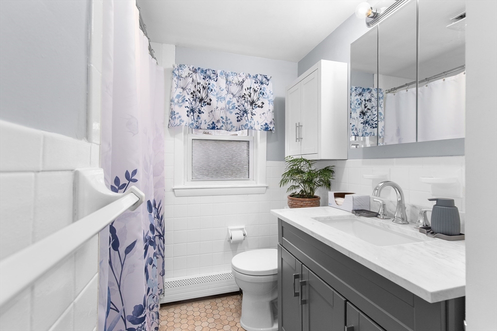 22 Baker Street Brockton, MA 02302 - Photo 17 of 32 a bathroom with a sink a toilet and a mirror