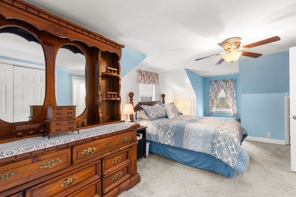 22 Baker Street Brockton, MA 02302 - Photo 23 of 32 a bedroom with a bed a chandelier and a mirror on dresser