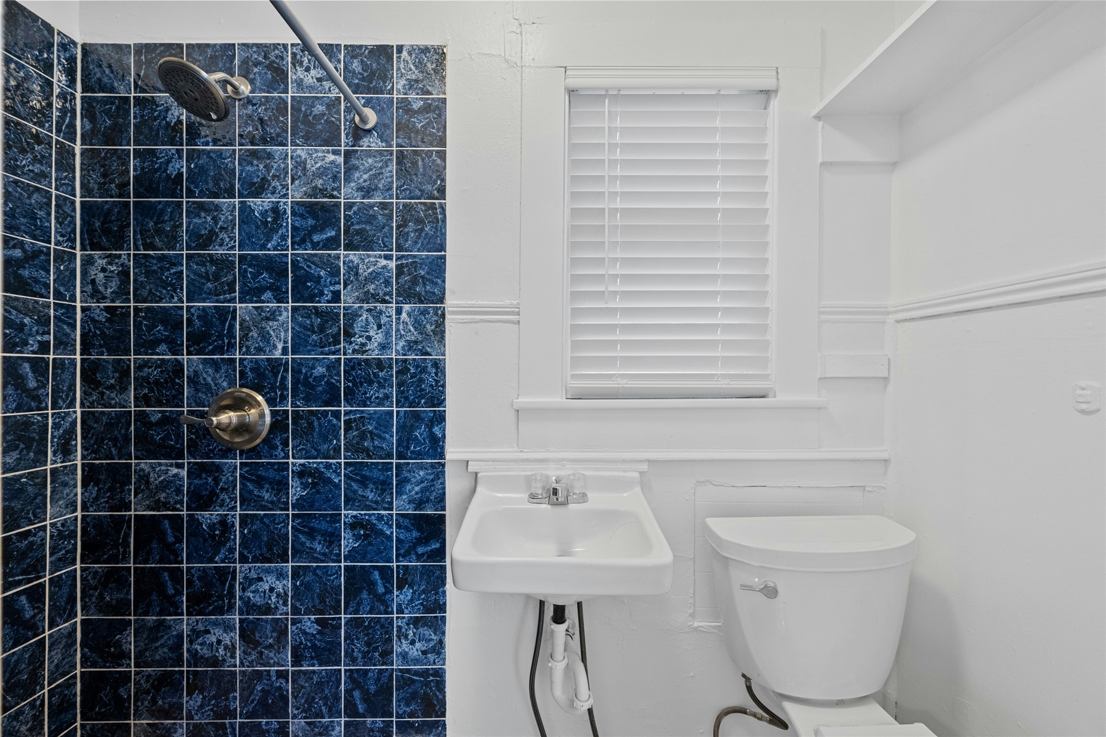 2201 Leon Street, Unit G Austin, TX 78705 - Photo 9 of 17 Shower stall featuring blue square tiling with a chrome shower head and handle