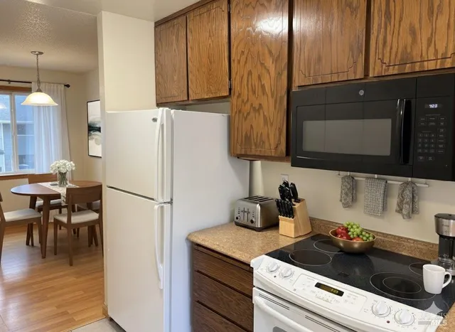 a kitchen with a refrigerator and a stove top oven