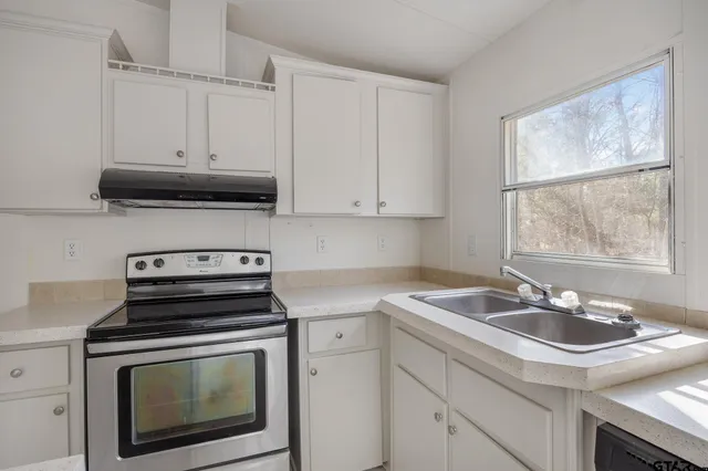 a kitchen with granite countertop a stove sink and microwave