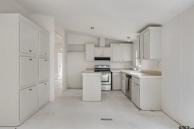 a kitchen with white cabinets and white appliances