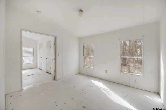 an empty room with windows and closet