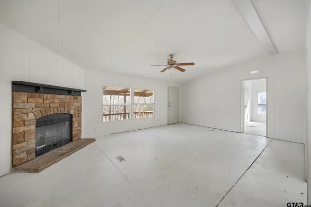 a view of empty room with windows and fireplace