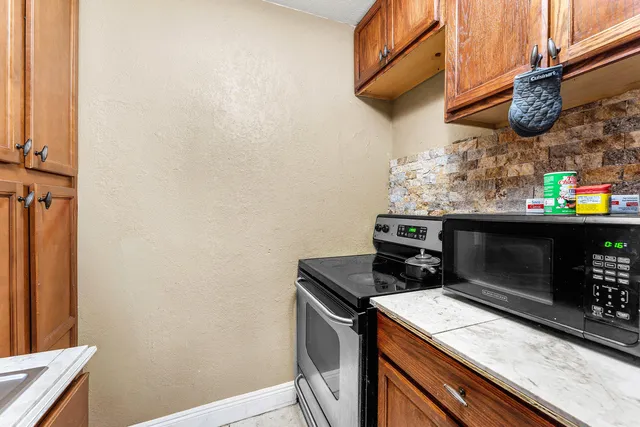 a kitchen with stainless steel appliances wooden cabinets and a stove