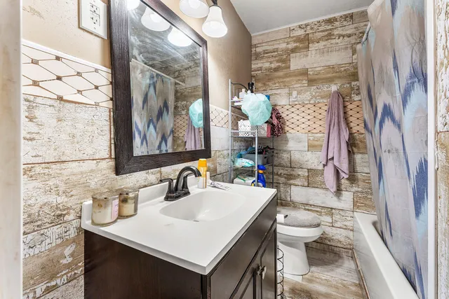 a bathroom with a sink vanity mirror and toilet