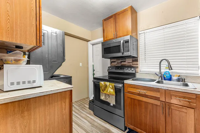 a kitchen with stainless steel appliances a stove a sink a microwave and refrigerator