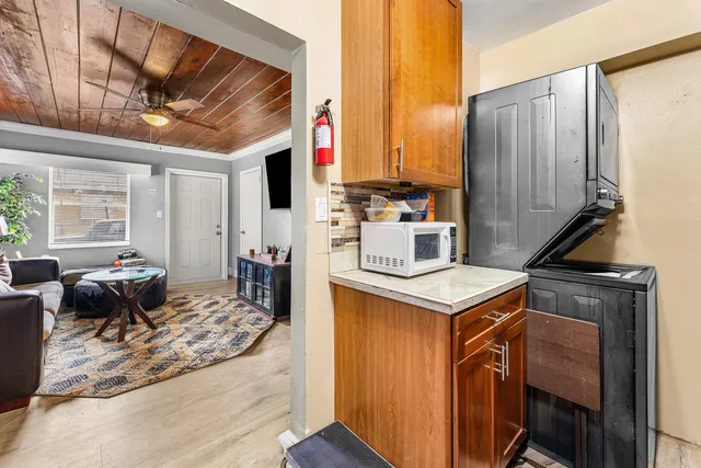 a kitchen with a stove a refrigerator and wooden floor