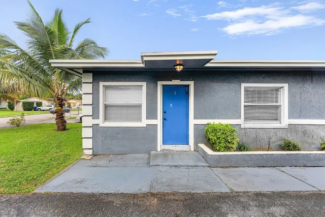 a view of a house with a large window and a yard