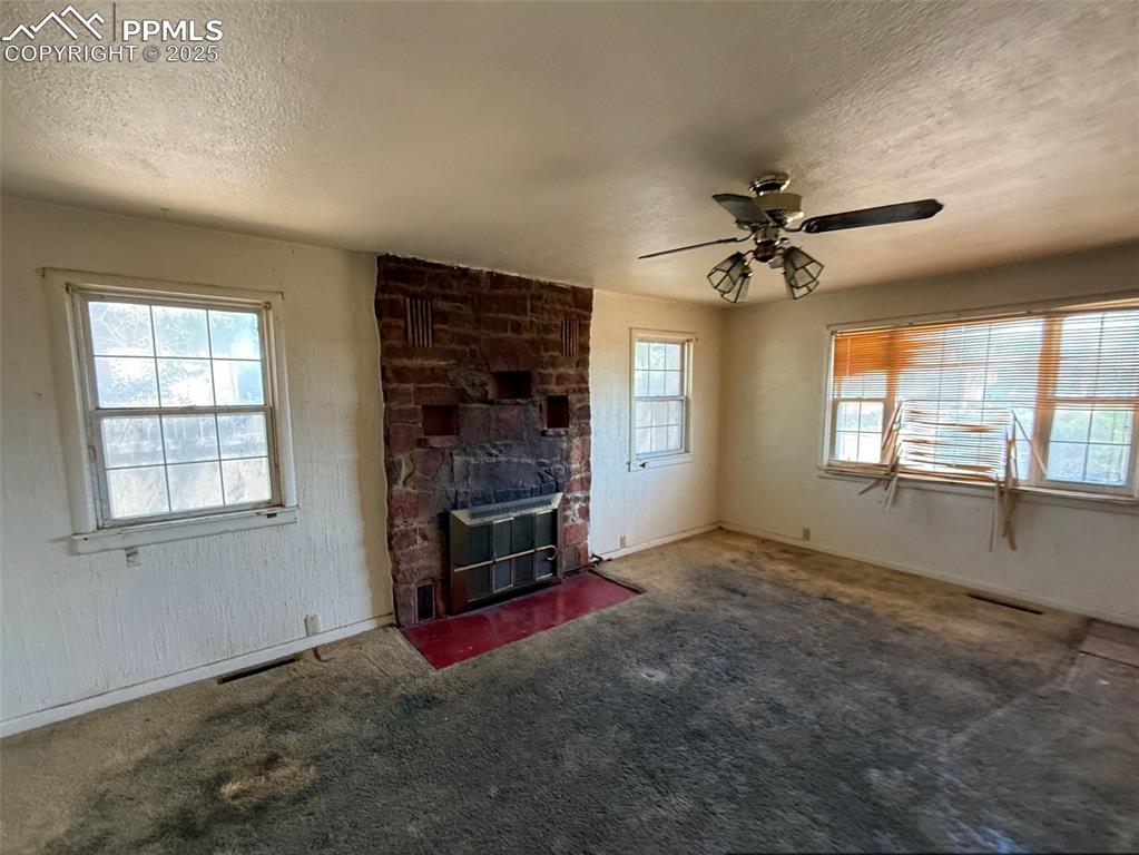 1117 West 6th Street La Junta, CO 81050 - Photo 4 of 18 an empty room with windows and chandelier fan