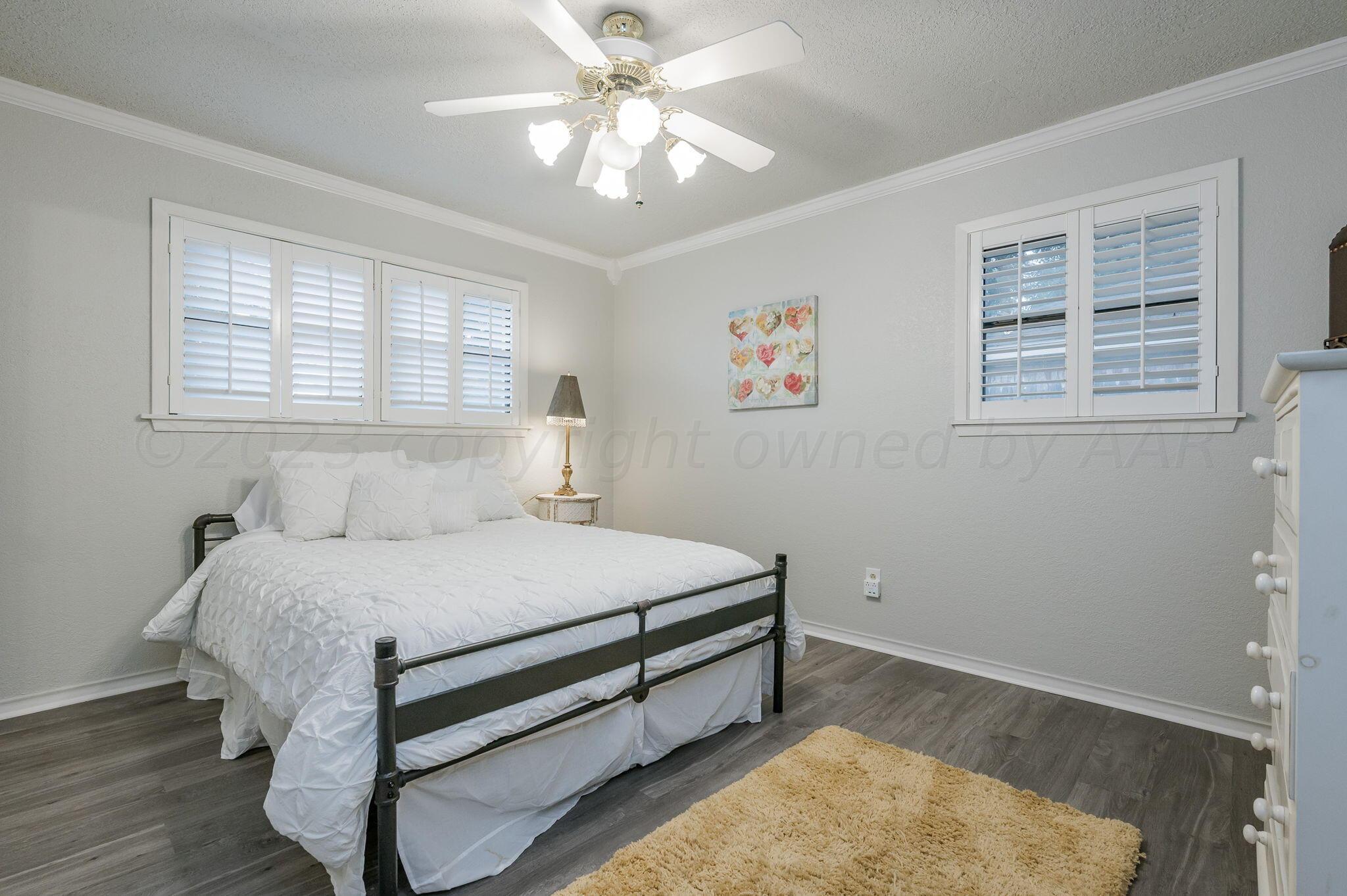 6019 Calumet Road Amarillo, TX 79106 - Photo 15 of 25 a bedroom with a bed and a chandelier