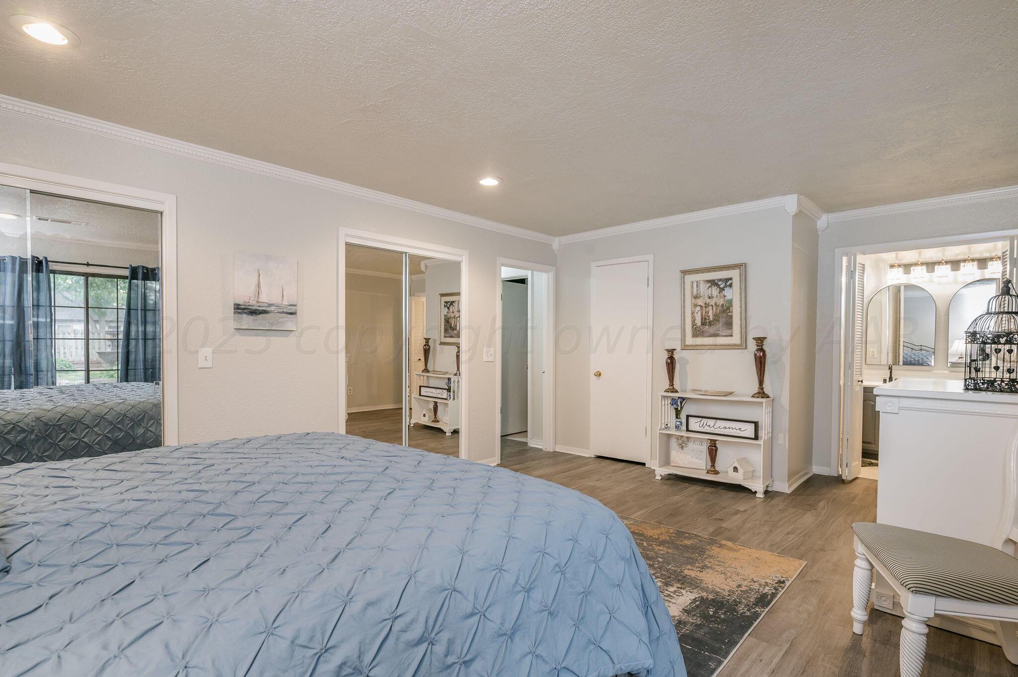 6019 Calumet Road Amarillo, TX 79106 - Photo 20 of 25 a spacious bedroom with a bed and cabinets