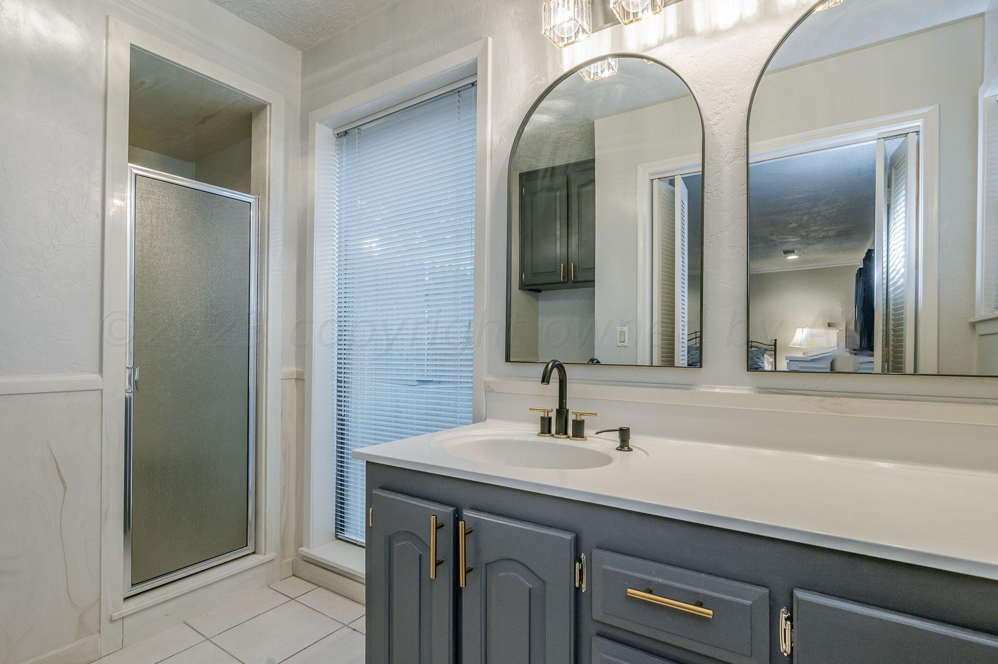 6019 Calumet Road Amarillo, TX 79106 - Photo 21 of 25 a bathroom with a double vanity sink and a mirror