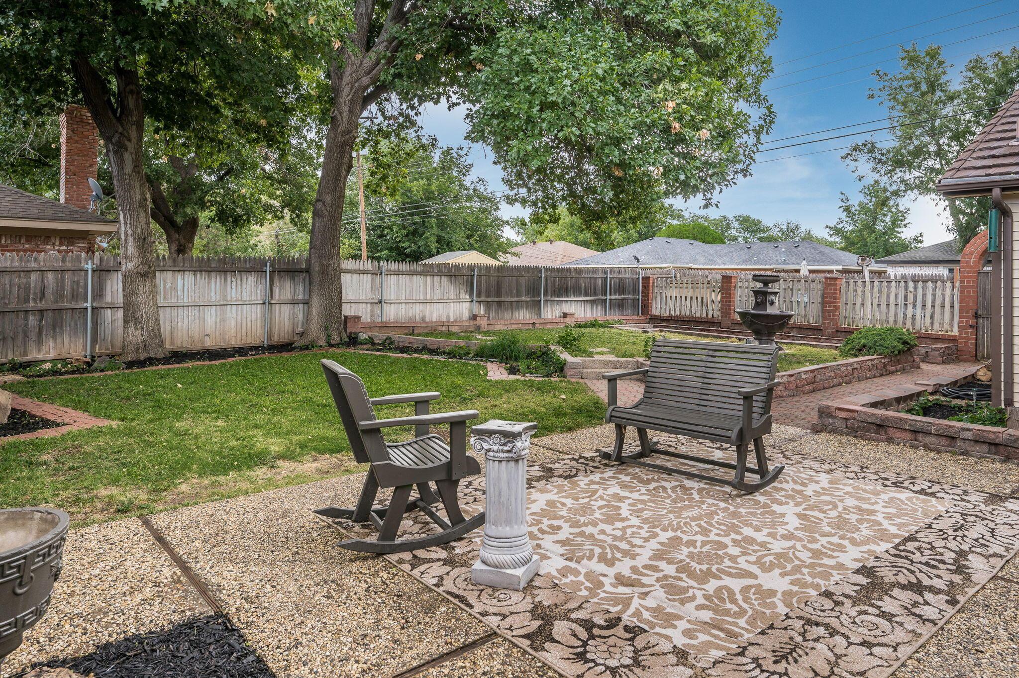 6019 Calumet Road Amarillo, TX 79106 - Photo 22 of 25 a view of a backyard with chairs potted plants and wooden fence