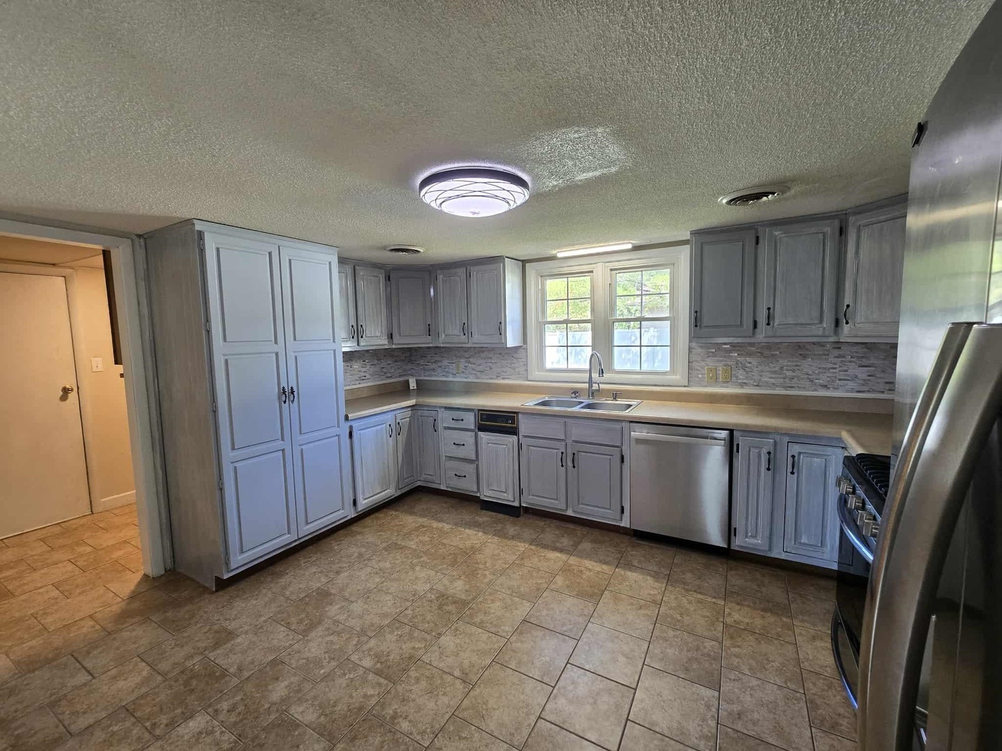 108 Mockingbird Lane Woodlawn, IL 62898 - Photo 22 of 43 a kitchen with granite countertop a stove a sink a window and cabinets