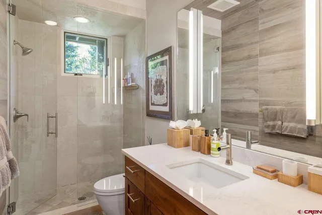 a bathroom with a sink a toilet and shower