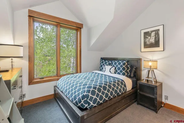 a bedroom with a bed lamp and a window