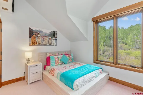 a bedroom with a bed and a large window