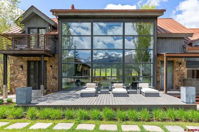 a living room with large windows and a table