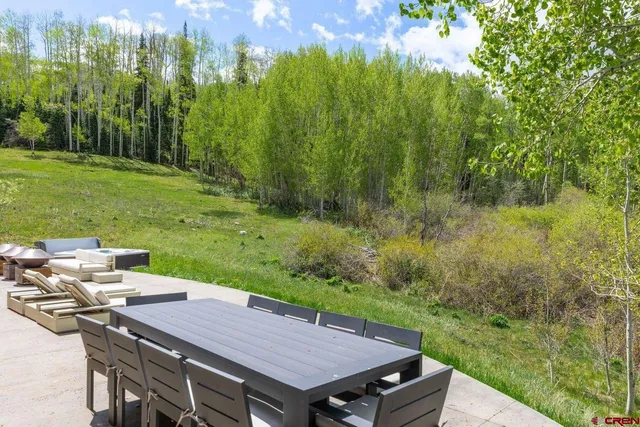 a view of a big house with a big yard and large trees