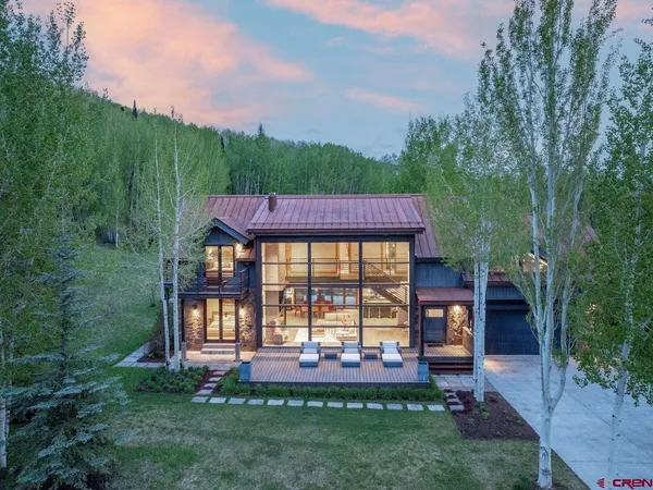 a view of a lush green forest with a house in the background