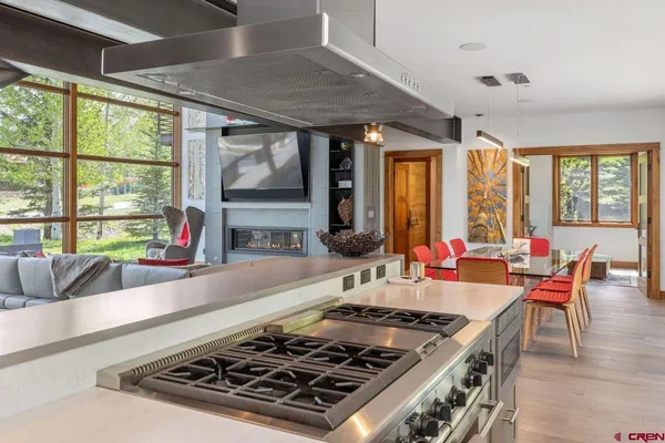 a kitchen with a stove a sink and a dining table with granite countertops