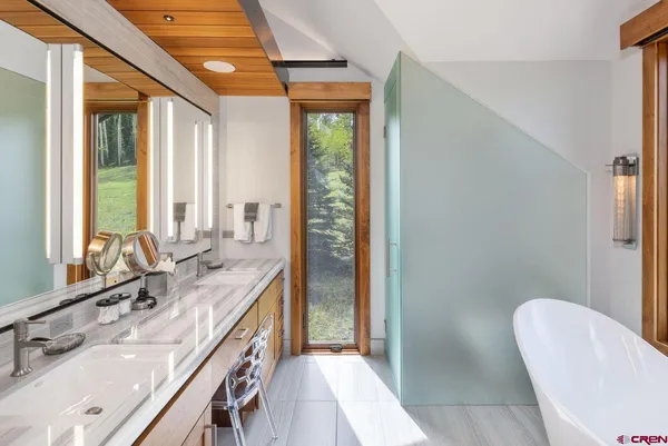 a bathroom with a double vanity sink a mirror and a bathtub