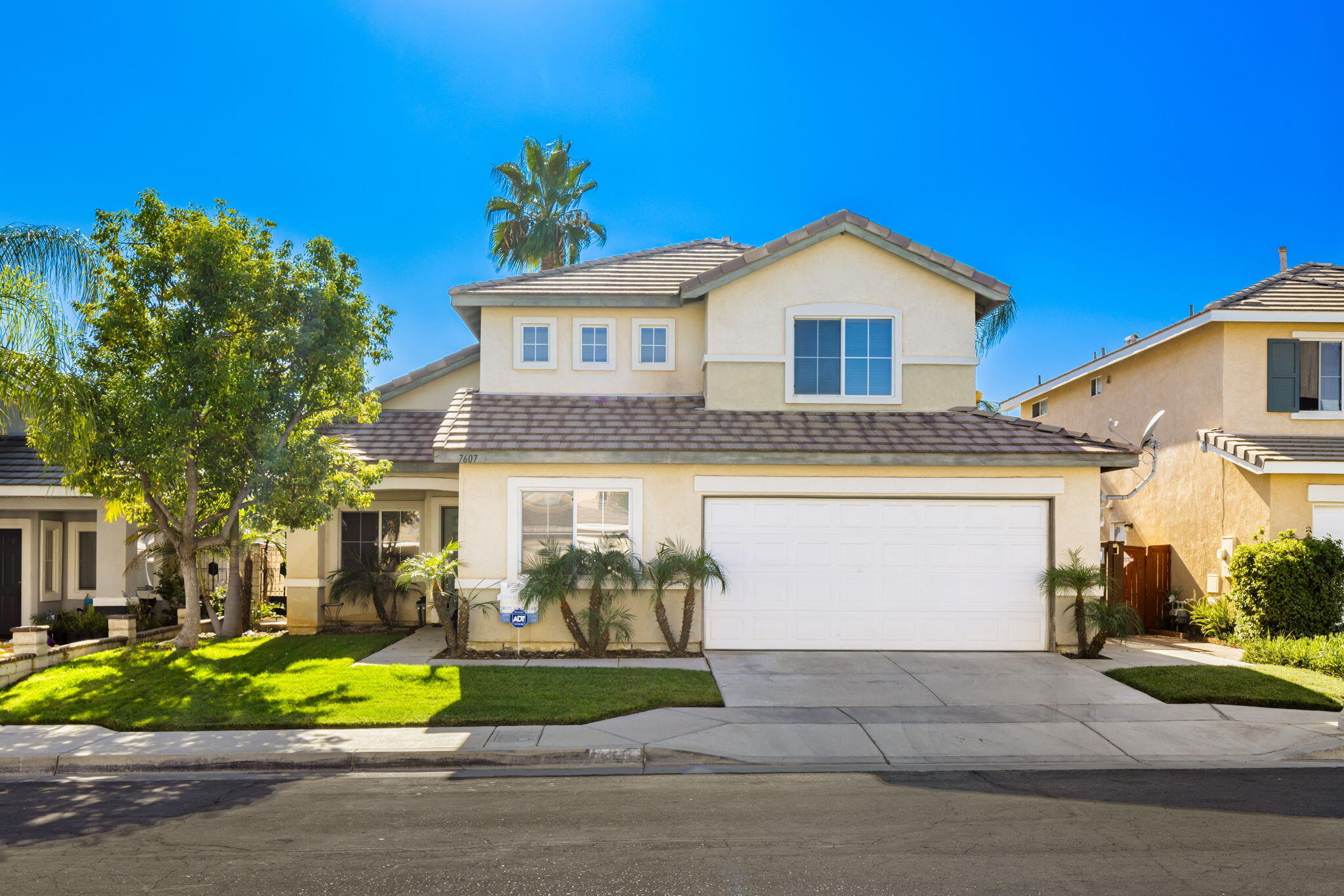 7607 Canberra Way Riverside, CA 92508 - Photo 2 of 28 a front view of a house with a yard and garage